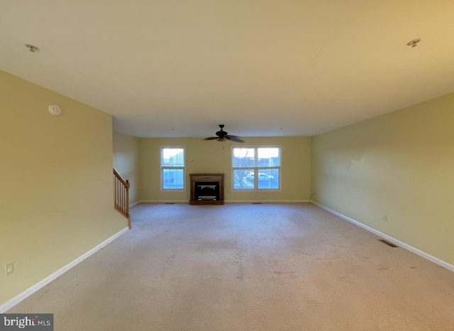 unfurnished living room with light colored carpet and ceiling fan