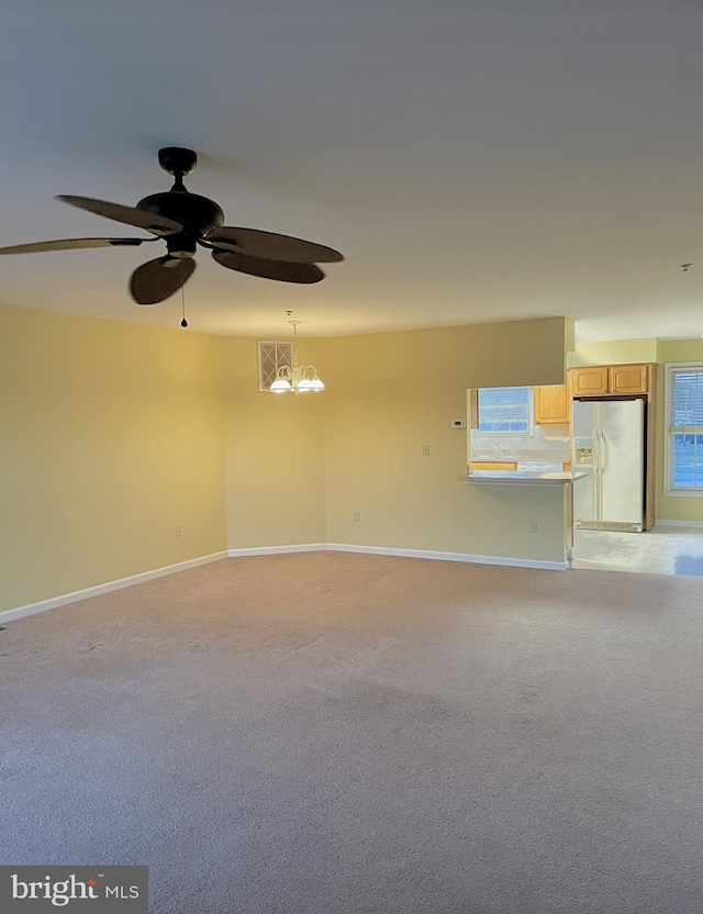 unfurnished room featuring ceiling fan with notable chandelier