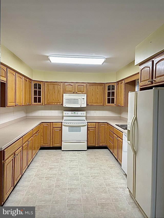 kitchen with decorative backsplash and white appliances