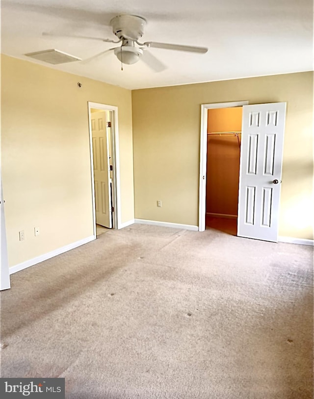 unfurnished bedroom with ceiling fan, a closet, carpet, and a spacious closet