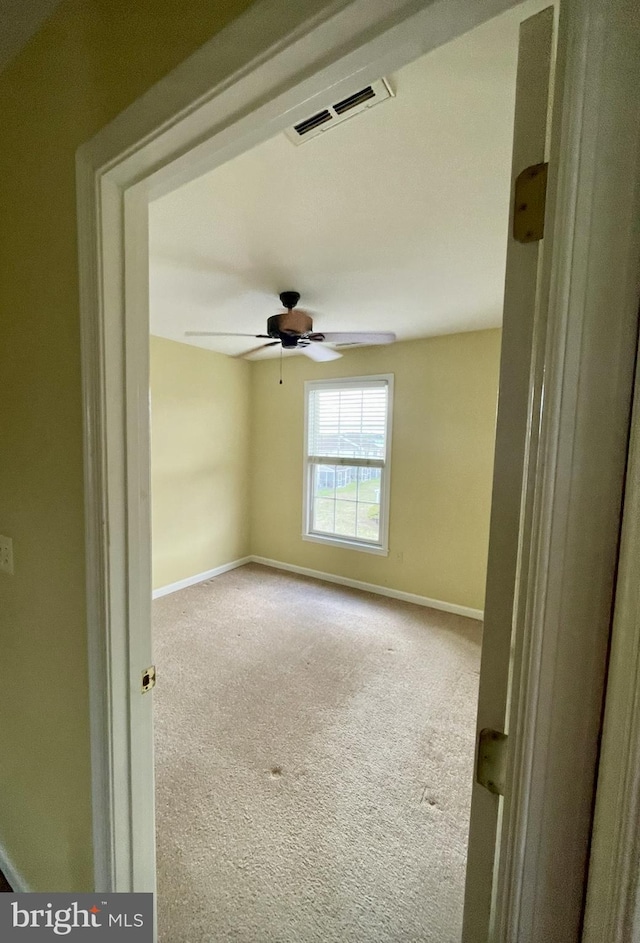 carpeted spare room with ceiling fan