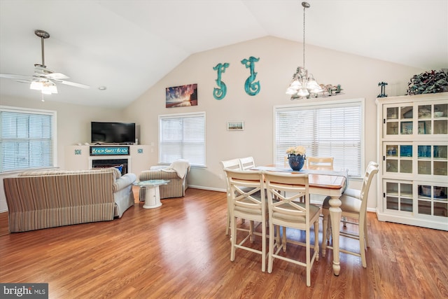 dining room with hardwood / wood-style floors, a healthy amount of sunlight, and lofted ceiling