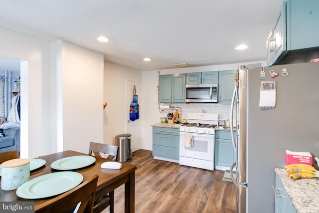 kitchen featuring appliances with stainless steel finishes, dark wood-type flooring, and decorative backsplash