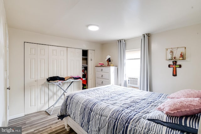 bedroom featuring cooling unit, wood-type flooring, and a closet