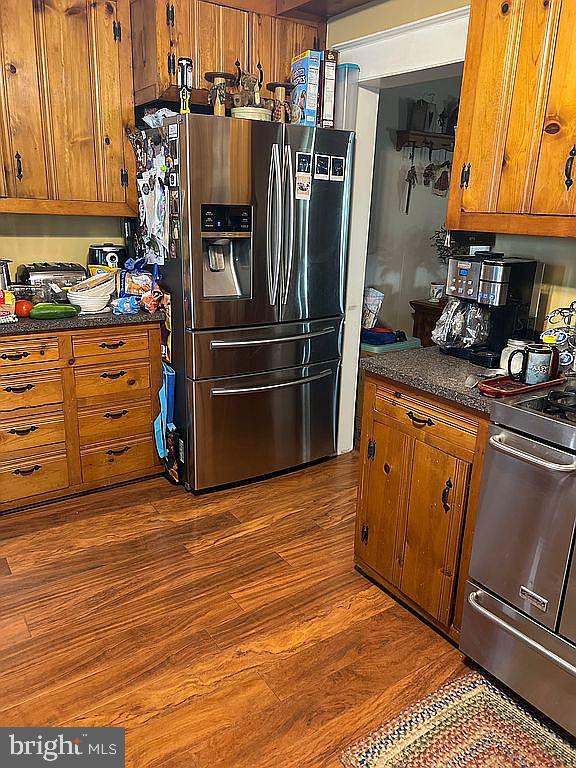 kitchen with dark hardwood / wood-style flooring and appliances with stainless steel finishes