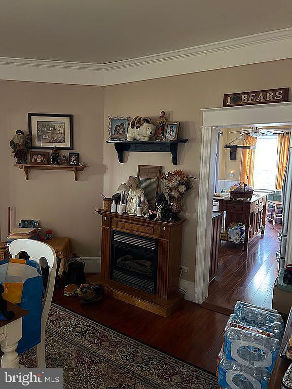 living room with wood-type flooring and ornamental molding