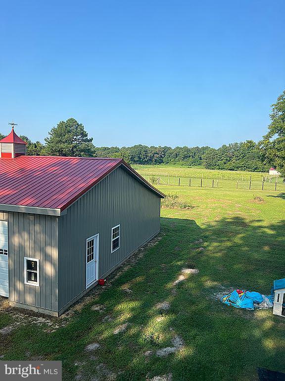 view of outdoor structure with a yard and a rural view