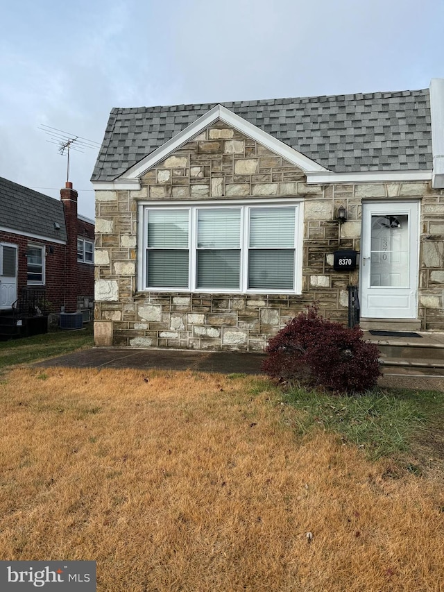 view of side of home featuring central air condition unit and a yard