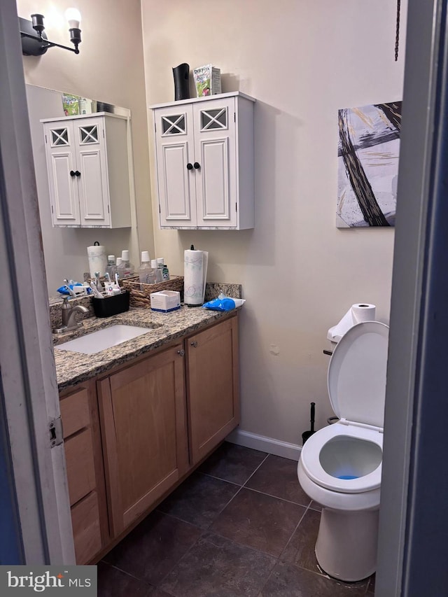 bathroom featuring toilet, vanity, and tile patterned floors