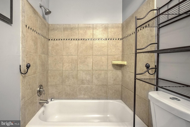 bathroom featuring toilet and tiled shower / bath