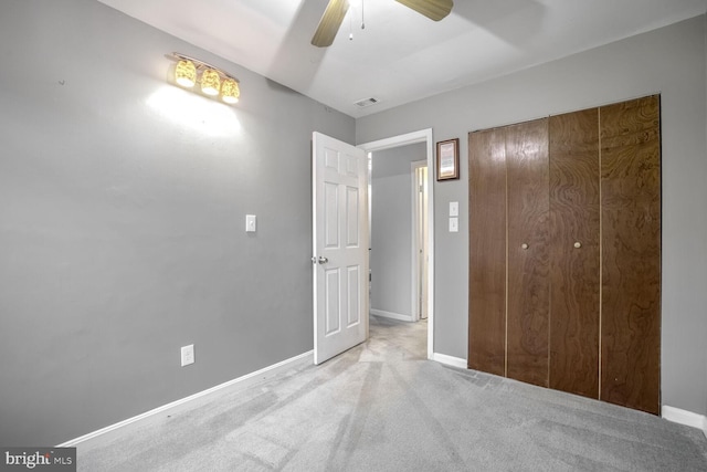 unfurnished bedroom featuring a closet, light colored carpet, and ceiling fan