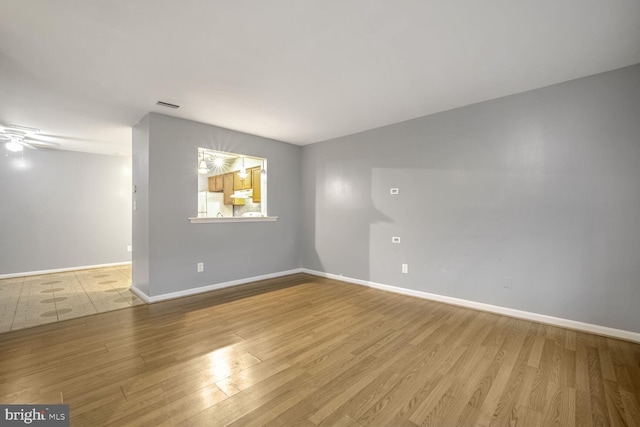 spare room with ceiling fan and light wood-type flooring