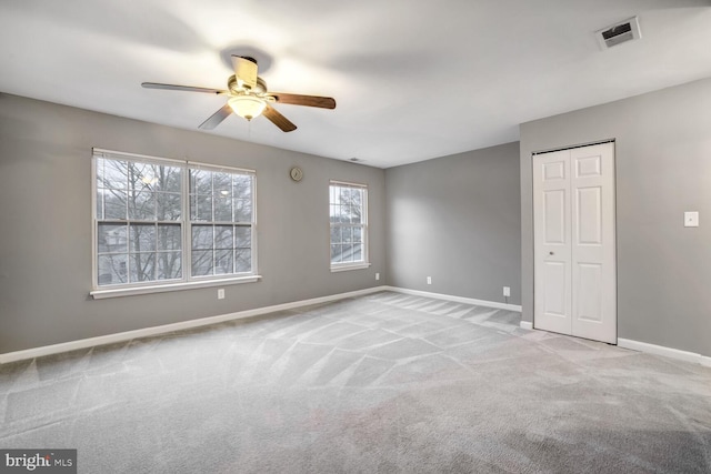 spare room featuring light colored carpet and ceiling fan