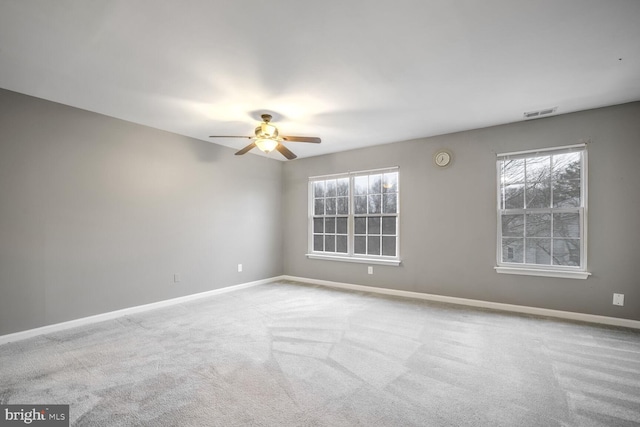 spare room featuring light colored carpet and ceiling fan