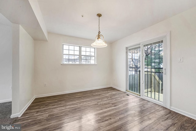 unfurnished dining area featuring a healthy amount of sunlight and wood-type flooring