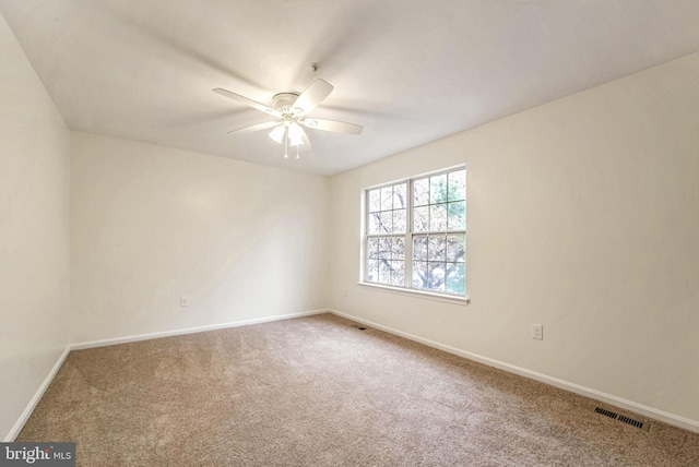 unfurnished room with ceiling fan and carpet