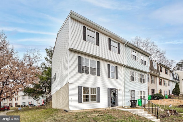 townhome / multi-family property featuring a front lawn