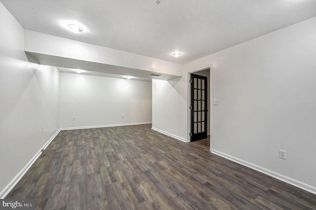 basement with dark hardwood / wood-style floors