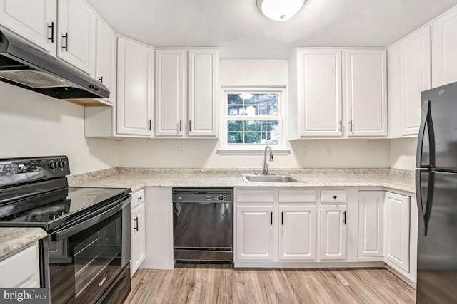 kitchen with black appliances, white cabinetry, sink, and light hardwood / wood-style flooring