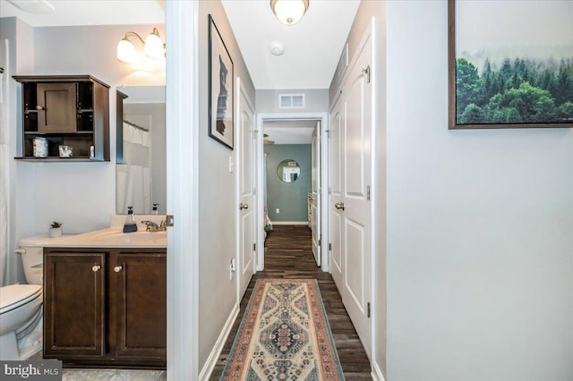 hallway with sink and dark wood-type flooring