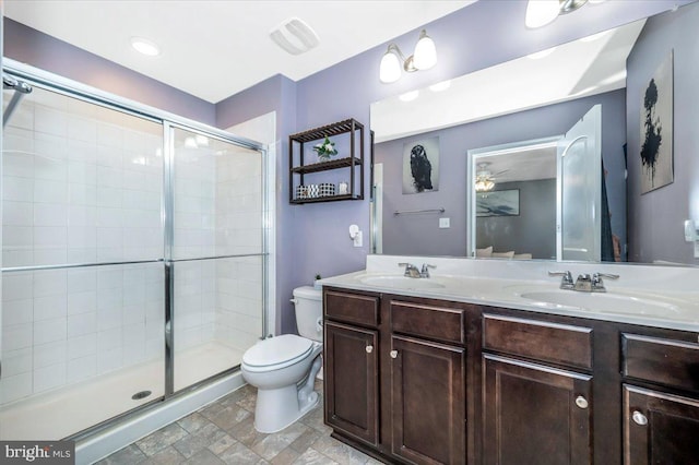 bathroom with ceiling fan, vanity, an enclosed shower, and toilet