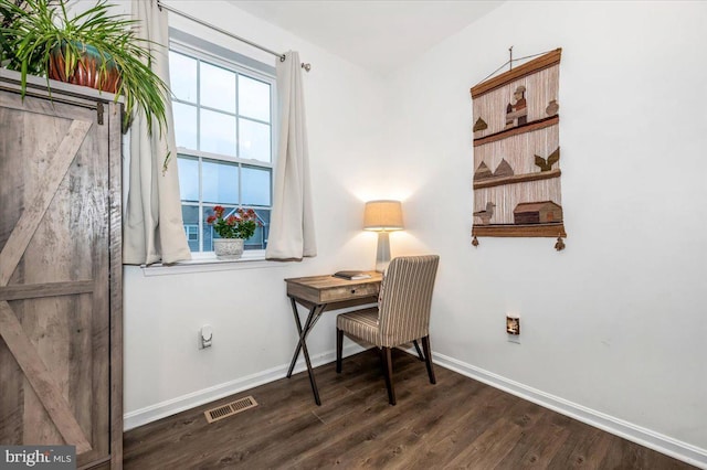 office featuring dark hardwood / wood-style floors and a barn door