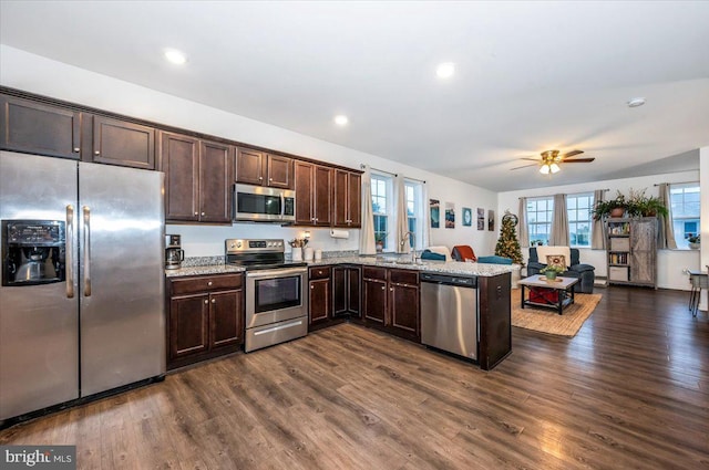 kitchen with ceiling fan, dark hardwood / wood-style flooring, kitchen peninsula, and appliances with stainless steel finishes