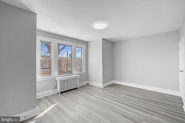 empty room featuring radiator and light hardwood / wood-style floors