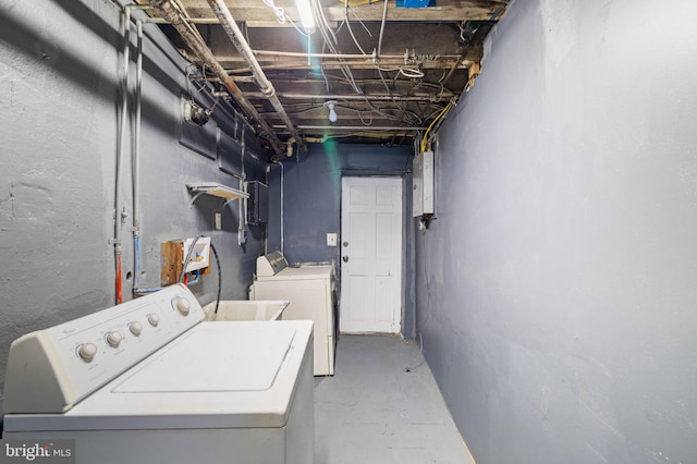 clothes washing area featuring electric panel and washer and clothes dryer