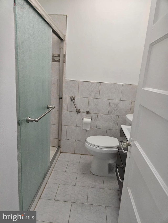 bathroom featuring tile patterned floors, an enclosed shower, tile walls, and toilet