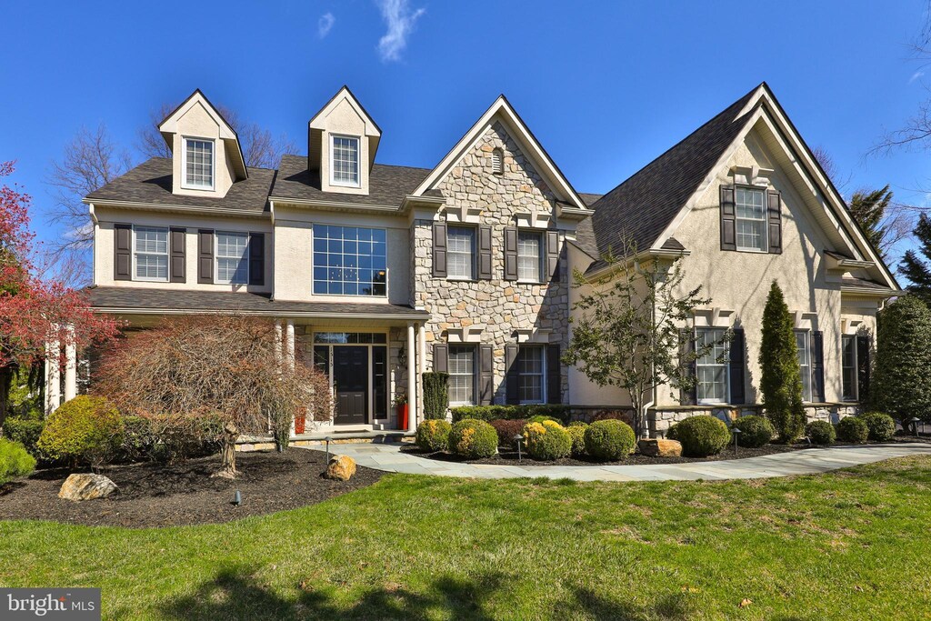 view of front of house with stone siding, a front lawn, and stucco siding