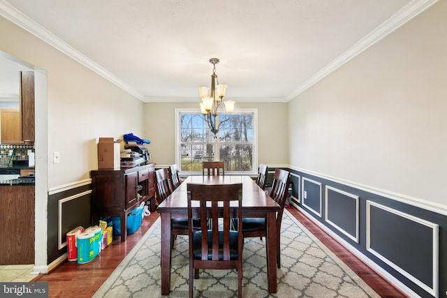 dining room featuring crown molding, dark wood-type flooring, and a chandelier