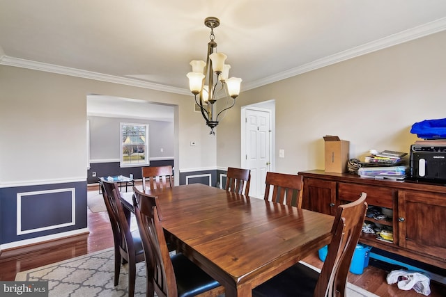 dining room featuring a chandelier, hardwood / wood-style flooring, and crown molding