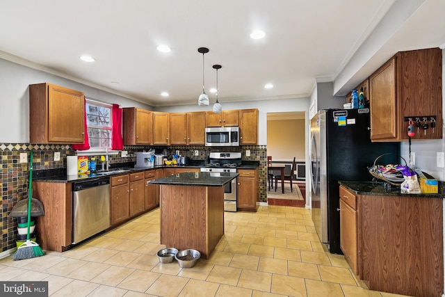 kitchen with a center island, stainless steel appliances, crown molding, dark stone counters, and pendant lighting