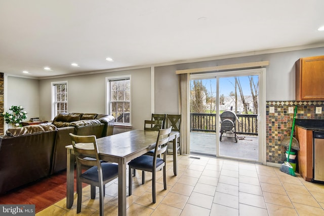 dining area with crown molding and light tile patterned floors