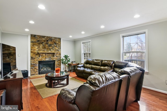 living room with hardwood / wood-style flooring, crown molding, and a fireplace