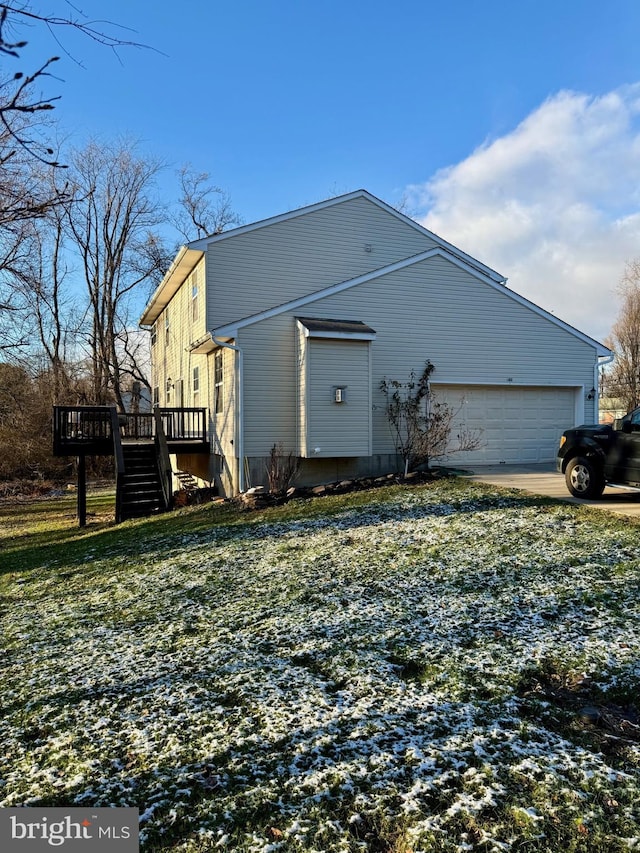 view of side of property featuring a garage and a wooden deck