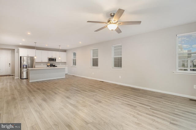 unfurnished living room featuring light hardwood / wood-style floors and ceiling fan