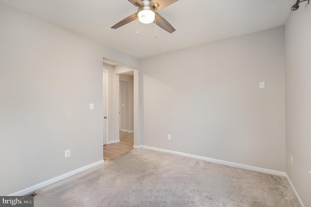 carpeted spare room with ceiling fan