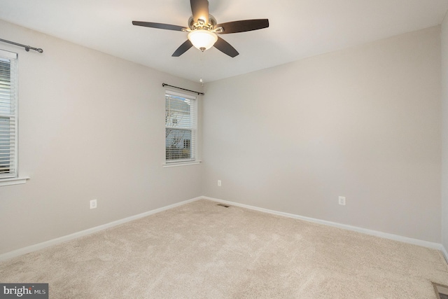 empty room featuring light colored carpet and ceiling fan