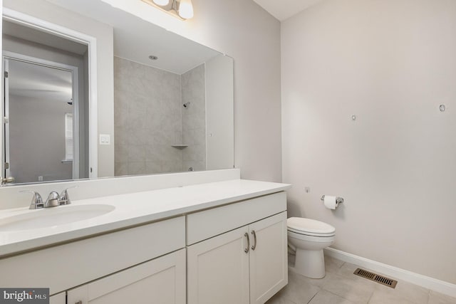 bathroom featuring tile patterned floors, vanity, toilet, and a tile shower