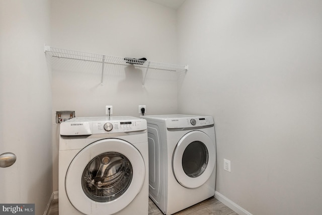 clothes washing area with light wood-type flooring and independent washer and dryer