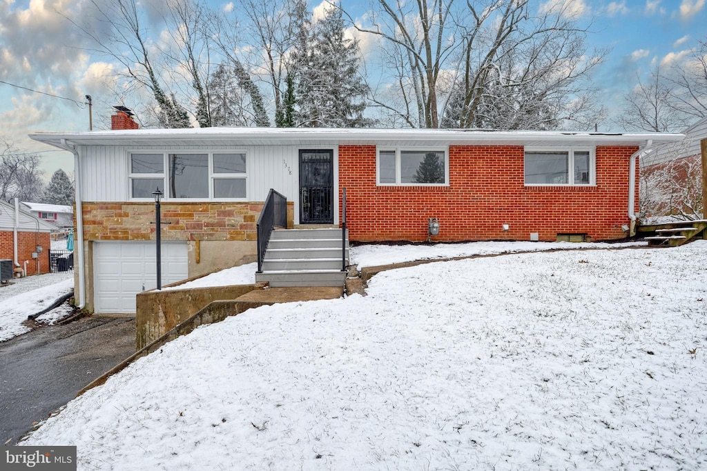 view of front of home with a garage and cooling unit