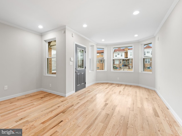 foyer entrance featuring crown molding and light hardwood / wood-style flooring