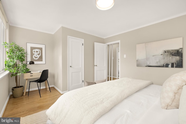 bedroom featuring light hardwood / wood-style floors and crown molding