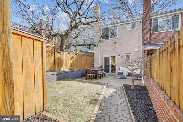 back of house with outdoor lounge area, a patio, and a lawn