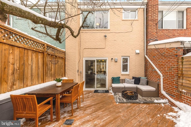 snow covered deck featuring an outdoor fire pit