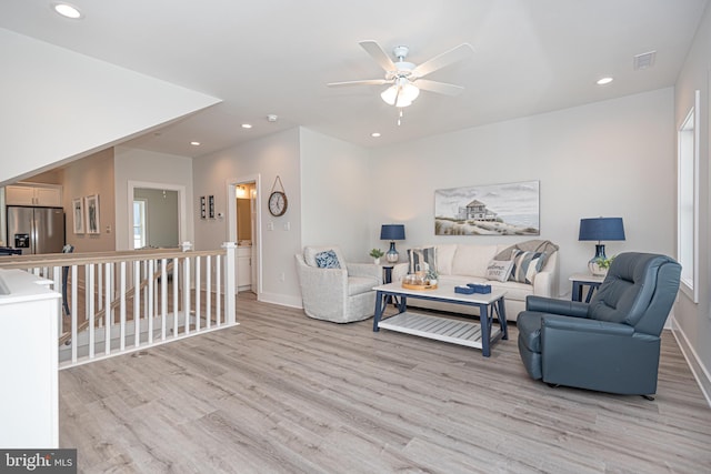 living room with light hardwood / wood-style flooring and ceiling fan