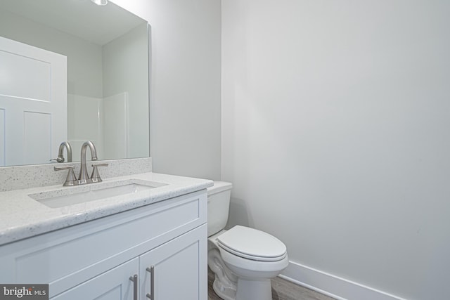 bathroom featuring hardwood / wood-style flooring, vanity, and toilet