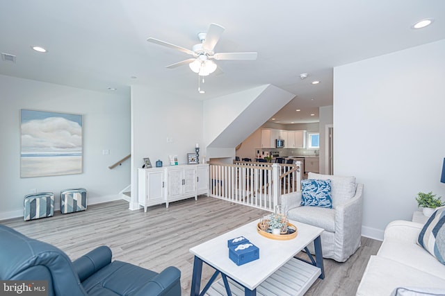 living room with ceiling fan and light wood-type flooring